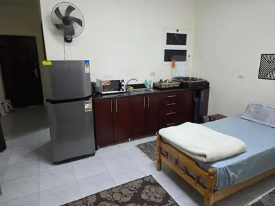 a kitchen with a refrigerator and a bed in a room at Lotus compound in Hurghada