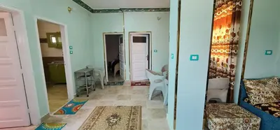 a living room with a mirror and a chair at The Green Nubian House in Aswan