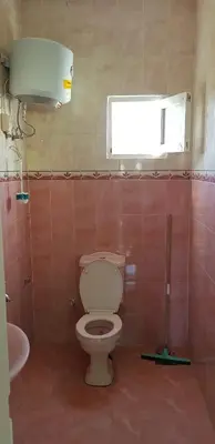 a bathroom with a toilet and a window and a sink at The Green Nubian House in Aswan