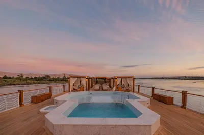 a hot tub on a deck with a view of a river at JAZ Elite Senator Nile Cruises - Every Thursday from Luxor for 07 Nights & Every Thursday from Luxor for 05 Nights in Luxor