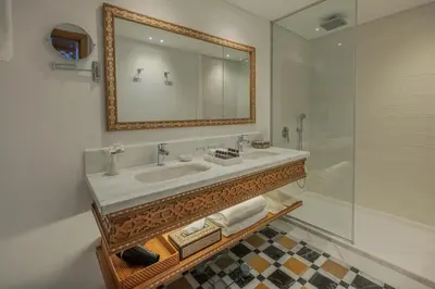 a bathroom with a sink and a mirror and a shower at JAZ Elite Senator Nile Cruises - Every Thursday from Luxor for 07 Nights & Every Thursday from Luxor for 05 Nights in Luxor