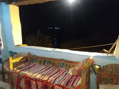 a room with a window with a bench on a balcony at Aswan Nubian House in Aswan