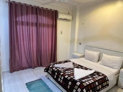 a bedroom with a bed and a purple curtain at Soliman Nile View in Luxor