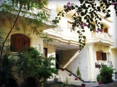 a white building with stairs in front of it at Bahga Palace 2 Residential Apartments in Hurghada