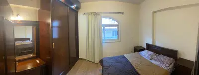 a bedroom with a bed and a dresser and a window at Bahga Palace 2 Residential Apartments in Hurghada