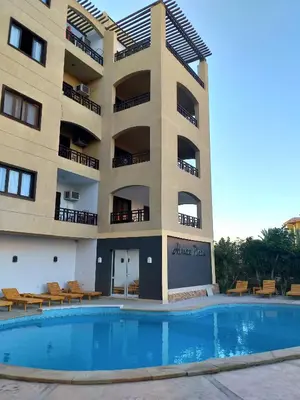 a hotel with a swimming pool in front of a building at Apartments in Almaz Plaza in Hurghada