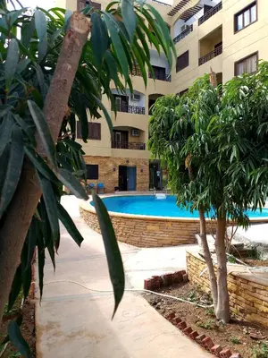 a swimming pool in front of a building at Apartments in Almaz Plaza in Hurghada