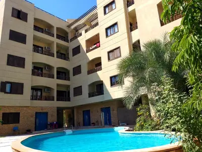 a building with a swimming pool in front of a building at Apartments in Almaz Plaza in Hurghada
