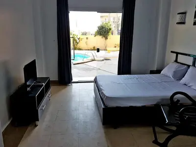 a bedroom with a bed and a view of a pool at Apartments in Almaz Plaza in Hurghada