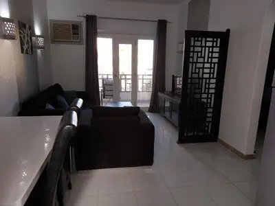 a living room with a couch and a door to a balcony at Apartments in Almaz Plaza in Hurghada