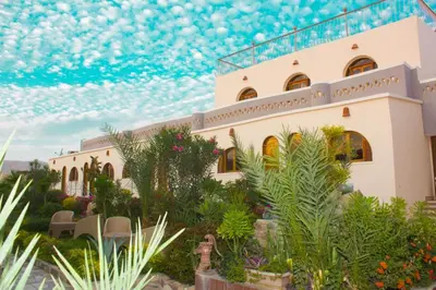 a house with a lot of plants in front of it at Janat Elsahara Hotel in Luxor