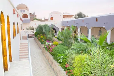 a courtyard of a building with flowers and plants at Janat Elsahara Hotel in Luxor