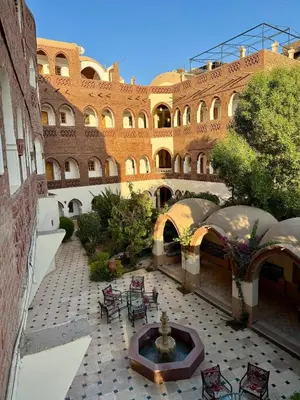 a courtyard with a fountain in front of a building at Hotel Sheherazade Luxor in Luxor