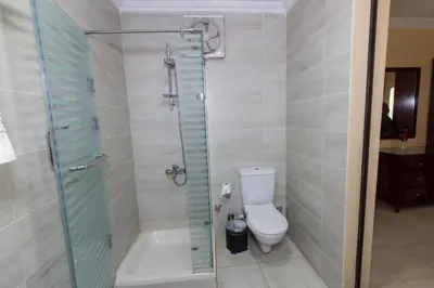 a bathroom with a toilet and a glass shower at Philae Hotel Aswan in Aswan