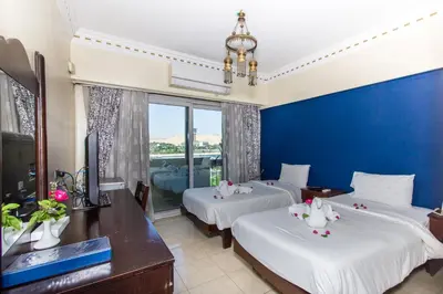 two beds in a room with a blue wall at Philae Hotel Aswan in Aswan