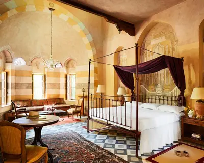 a bedroom with a bed and a living room at Al Moudira Hotel in Luxor