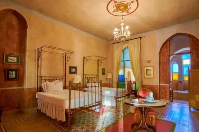 a bedroom with a bed and a chandelier at Al Moudira Hotel in Luxor