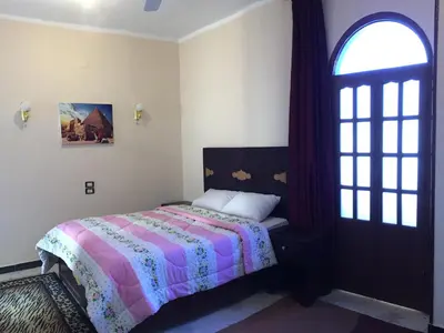 a bedroom with a bed and a window and a door at Sunflower Guest House Luxor West Bank in Luxor