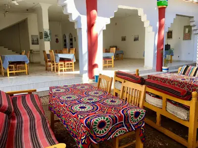 a dining room with two tables and chairs and a room with tables and chairs at Sunflower Guest House Luxor West Bank in Luxor