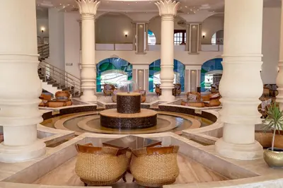 a lobby with columns and a fountain and tables at Coral Hills Resort & SPA in Quseir