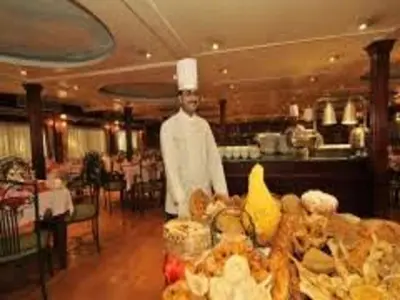 a chef standing in front of a table of food at Nile Cruises 5 Stars From From Aswan 03 Nights -From Luxor 04 Nights in Luxor