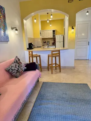a living room with a couch and a kitchen at South Marina El Gouna 1 BR in Hurghada