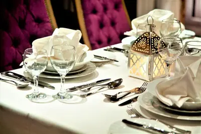 a table with plates and wine glasses on it at Steigenberger Legacy Nile Cruise - Every Monday 07 & 04 Nights from Luxor - Every Friday 03 Nights from Aswan in Luxor