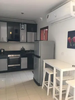 a kitchen with a stainless steel refrigerator and a table at Pool View One bedroom Apt - B103 in Hurghada