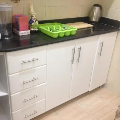 a kitchen counter with white cabinets and a green tray on it at Sweet Home Flat 2- 24 Hour open in Hurghada
