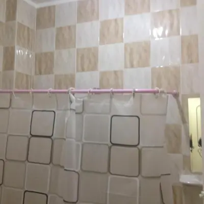 a white tiled bathroom with a pink shower curtain at Sweet Home Flat 2- 24 Hour open in Hurghada