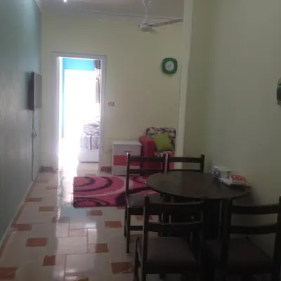a living room with a table and chairs and a bedroom at Sweet Home Flat 2- 24 Hour open in Hurghada