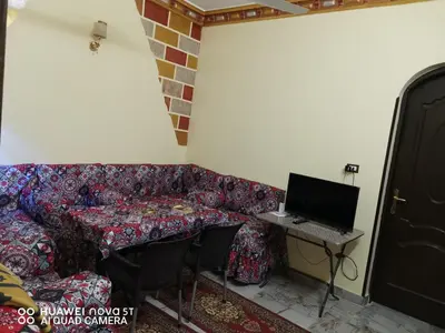 a room with a couch and a desk with a laptop at King Nubian House in Aswan