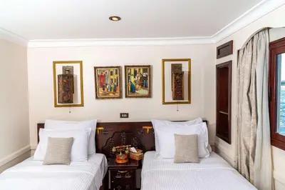 two beds in a room with white walls at Sonesta Dahabeya Amirat I - Nile Cruise Ship From Luxor to Aswan 7 nights in Luxor