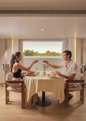 a man and woman sitting at a table with glasses of wine at Sonesta Star Goddess Cruise - Luxor- Aswan - 04 & 07 nights Each Saturday in Luxor