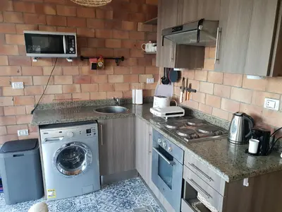 a kitchen with a washing machine and a washer at One Bedroom Chalet managed by Lilly Homes in Hurghada