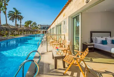 a hotel with a pool and a bed and chairs at Sunrise Aqua Joy Resort in Hurghada