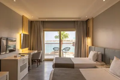a hotel room with two beds and a balcony at Sunrise Crystal Bay Resort -Grand Select in Hurghada