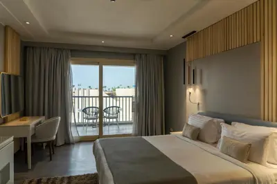 a hotel room with a bed and a balcony at Sunrise Crystal Bay Resort -Grand Select in Hurghada