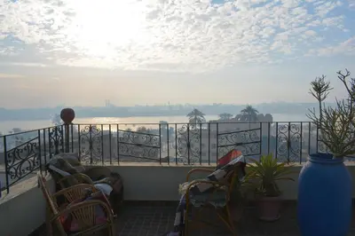a balcony with chairs and a view of the water at Harmony House Luxor in Luxor