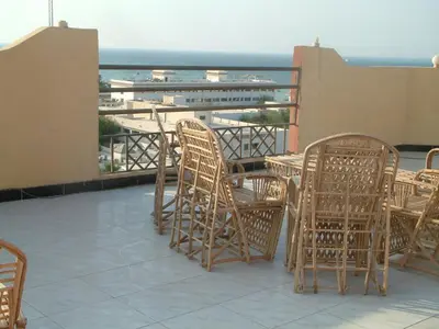 a group of chairs and tables on a balcony with the ocean at Diana Hotel Hurghada in Hurghada