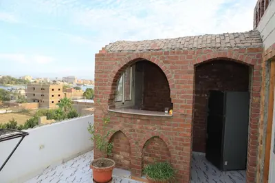 a brick building with a window on a balcony at Memnoun house in Luxor