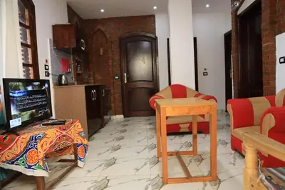 a living room with a tv and a table and chairs at Memnoun house in Luxor