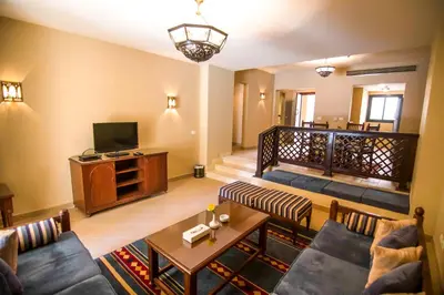 a living room with a couch and a tv at Marina Residence Suites Port Ghalib in Port Ghalib