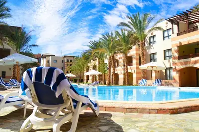 a lounge chair sitting next to a swimming pool at Marina Residence Suites Port Ghalib in Port Ghalib
