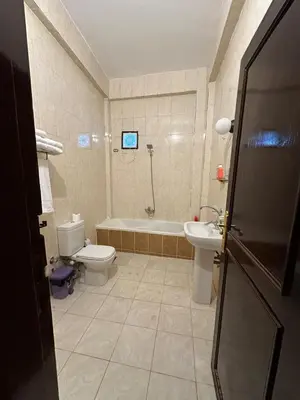 a bathroom with a tub and a toilet and a sink at Eka- Guesthouse in Aswan