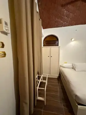 a bedroom with a bed and a chair in a room at Eka- Guesthouse in Aswan