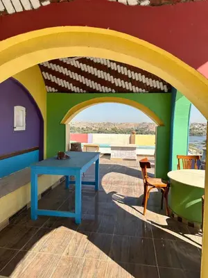 a table and chairs in a room with a colorful wall at Eka- Guesthouse in Aswan