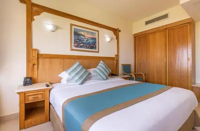 a bedroom with a large bed with a wooden headboard at Hurghada Long Beach Resort in Hurghada