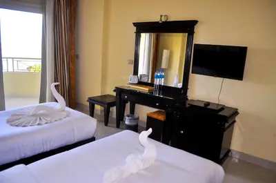 a hotel room with two beds and a mirror at Magic Beach Hotel Hurghada in Hurghada