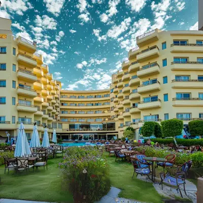 a hotel with tables and chairs in front of a building at Magic Beach Hotel Hurghada in Hurghada